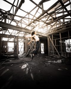 A girl jumping with joy in a demolished factory