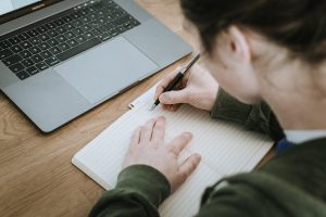 Girl writing down contact information in a notebook.