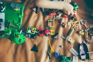 Bunch of kid toys on bed sheet.