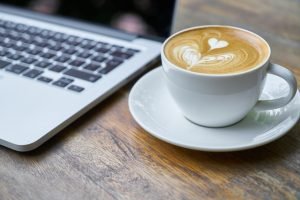 Cup of coffee next to the laptop.