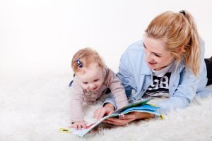 Woman and baby girl looking at the book 