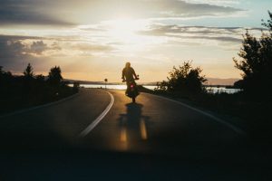 a man rifing a motorcycle on an empty road