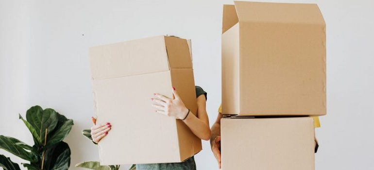 a couple holding moving boxes