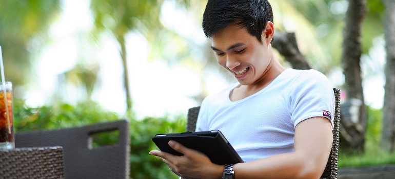 A happy man using the internet to find interstate movers Connecticut