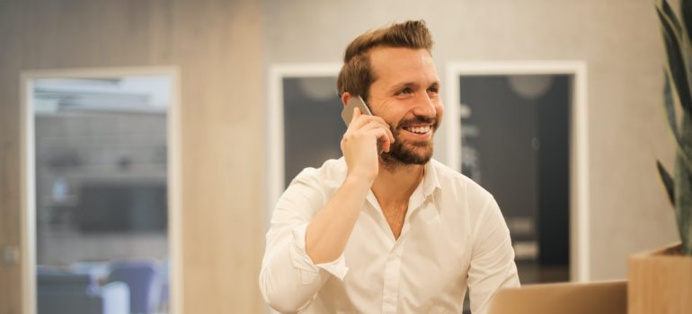 Smiling man talking with interstate movers Texas over the phone