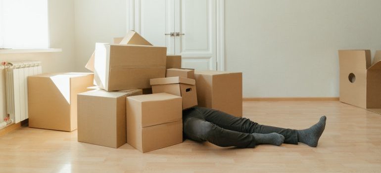 person under a stack of cardboard boxes