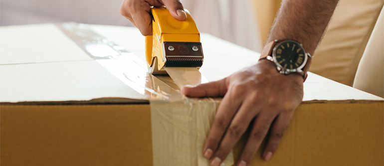 A member of international movers Idaho packing a box