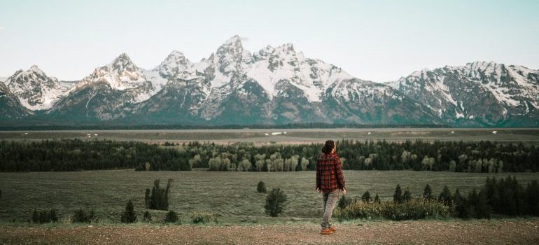 man in red jacket in front of a snow covered mountain