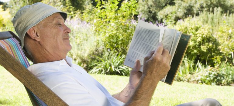 a man sitting in a lawn chair reading about interstate movers Arkansas