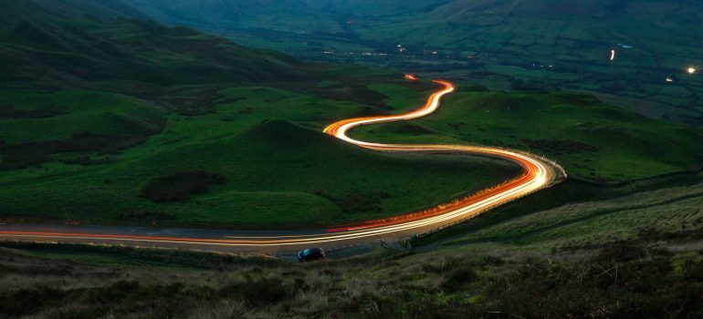 Road between green grass field