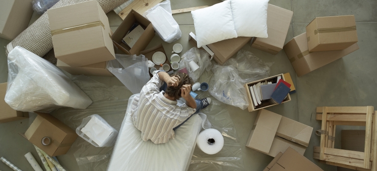 a man sitting between unpacked boxes