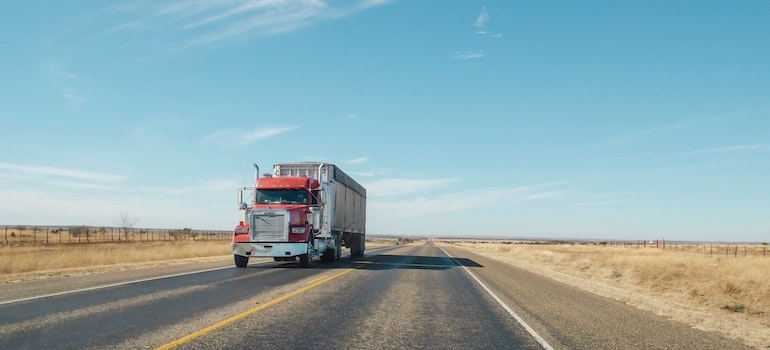 A truck on a desert road, depicting the best cross country movers in Rochester.