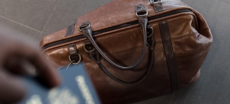 person holding a passport , bag on the ground