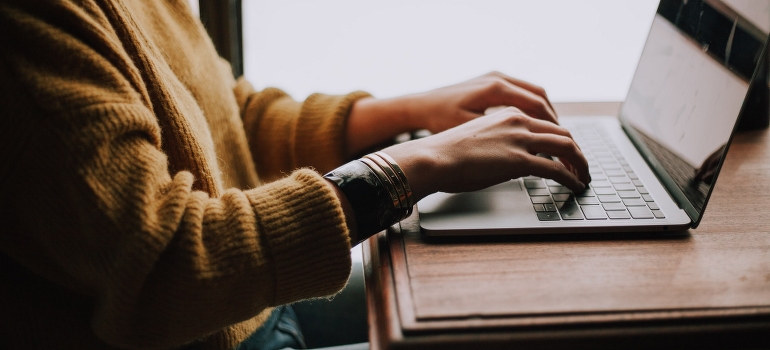 a woman using laptop to find movers NYC to Chicago