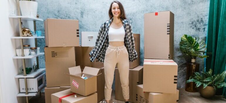 woman among moving boxes preparing for moving to north carolina from new york