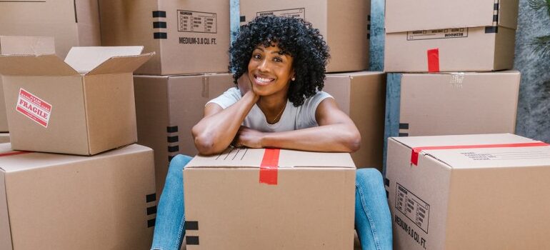 woman smiling in the midle of cardboard boxes