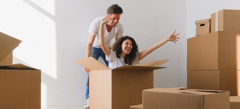 man and woman having fun amid moving boxes