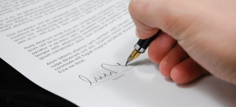 a person signing a paper