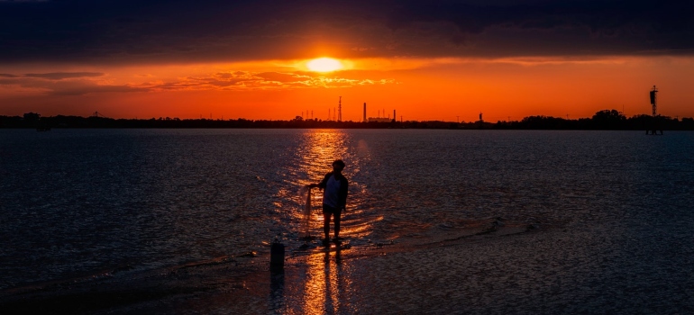 a person at the beach with an orange sunset on the horizon to represent Jacksonville, Florida as one of the best places in the US for nature lovers
