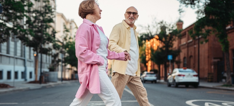 Happy Elderly Couple Holding Hands while Crossing on the Pedestrian Lane.