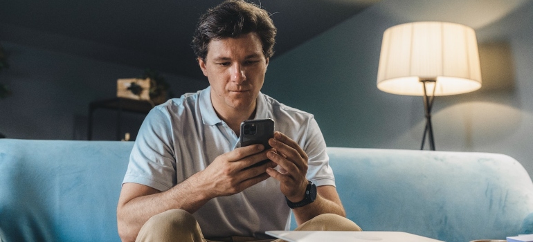 a man on a phone looking for moving discounts and deals of 2022 