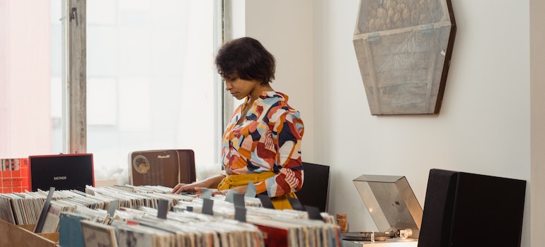 A Woman Browsing at Vintage Vinyl Music Records - pack vinyl records for moving.