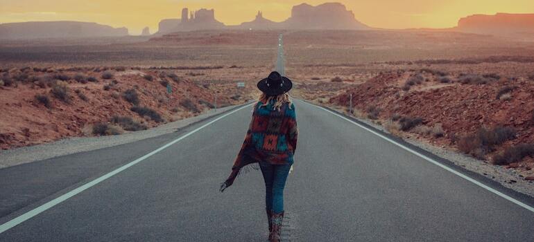 A woman walking down a paved road 