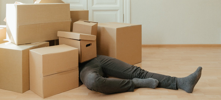A person overrun by a pile of boxes