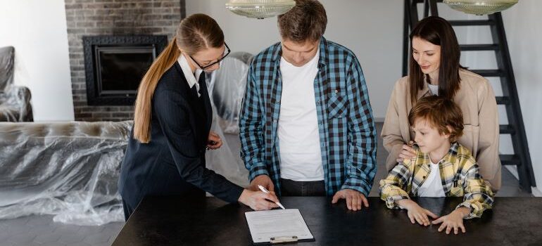 a woman showing a man where to sign a document