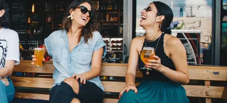Two women smiling and drinking after moving from Tampa to San Jose