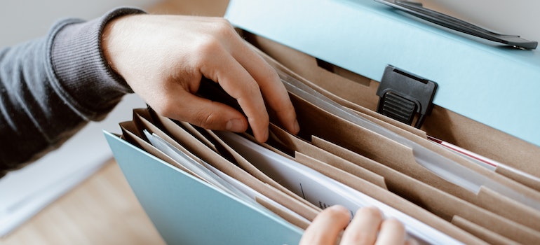 A person searching for documents in the folder.