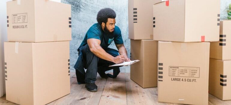A bearded man checking the moving boxes