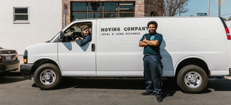 A moving crew standing in front of a moving van