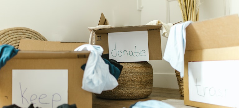 Boxes with clothes that is sorted out to be donated, kept or thrown away