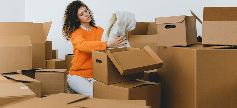 Woman looking at a white blanket while unpacking