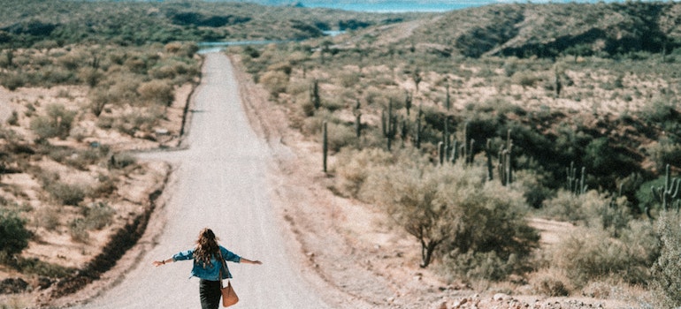 a woman walking down the dessert road after moving from Los Angeles to Phoenix