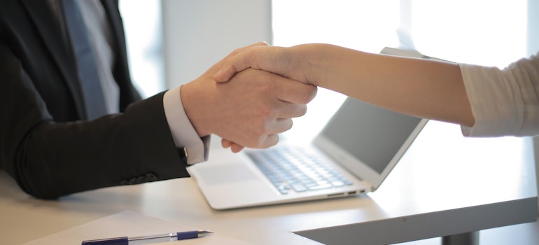 Two people shake hands at a job interview after moving from California to Colorado