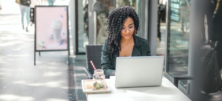 A woman searching for the best cross country movers Lakeville has to offer on her laptop