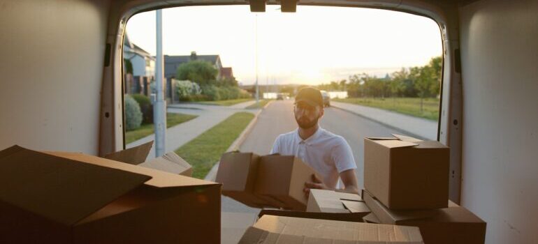 man putting boxes inside a van