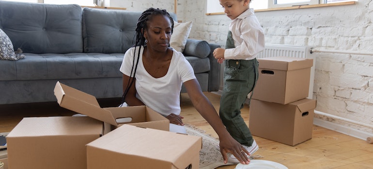 A woman packing her belongings with her small son to move across the country with best cross country movers Lakewood