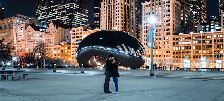 a couple in Chicago standing in front of the Bean statue