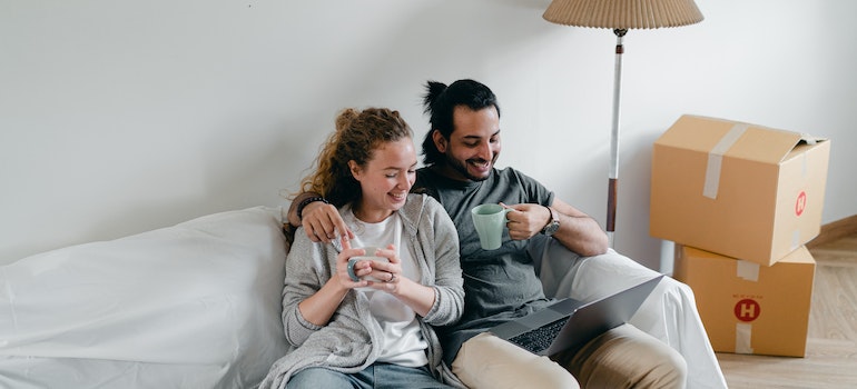 A couple looking at laptop and searching for some of the best cross country movers Greeley