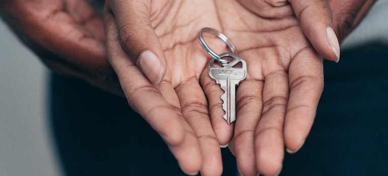 Couple holding a silver key in their interlocked hands