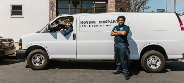 Two guys from a moving company standing near a white van