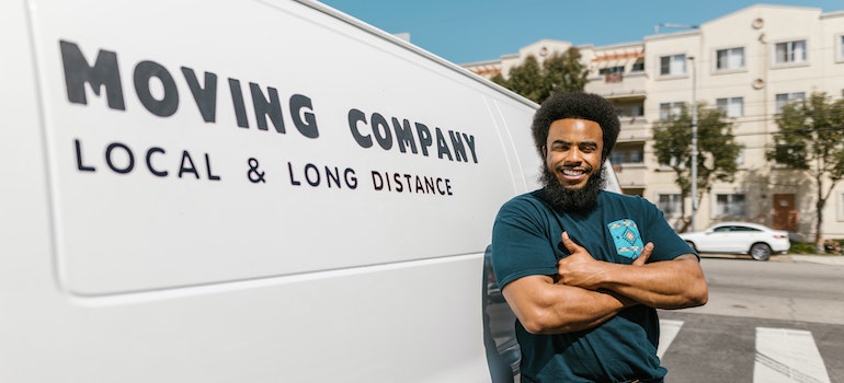 a mover from best cross country movers Alpharetta standing next to a van