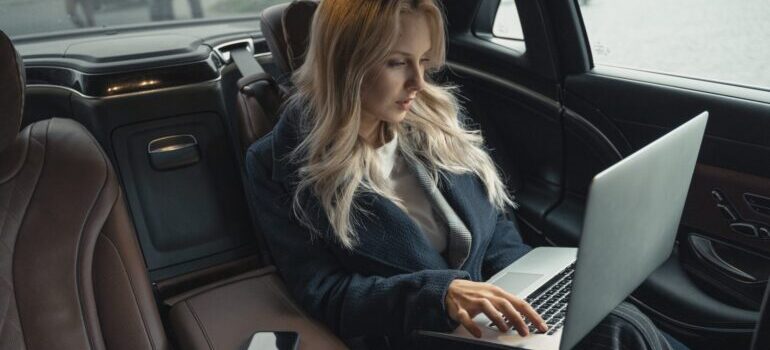 Woman in the car using her laptop
