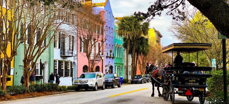 people riding on carriage after moving from South Carolina to Florida in the street with colorful buildings