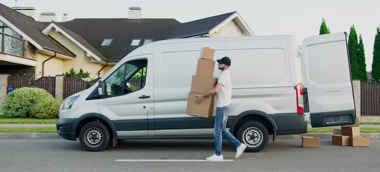 one of the best cross country movers Danbury carrying boxes from a white van into a house 