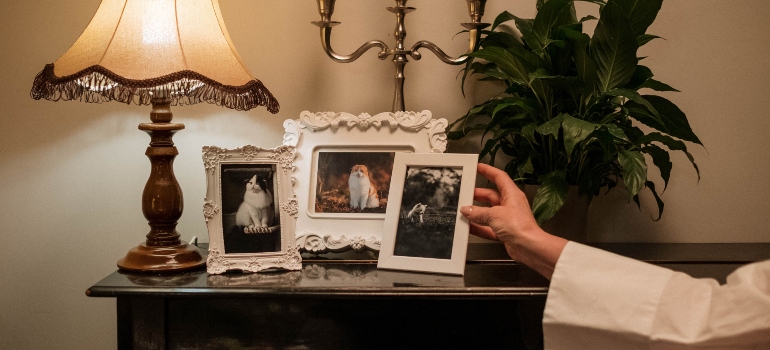 A woman holding a framed photo of her pet deciding if she want to declutter sentimental items