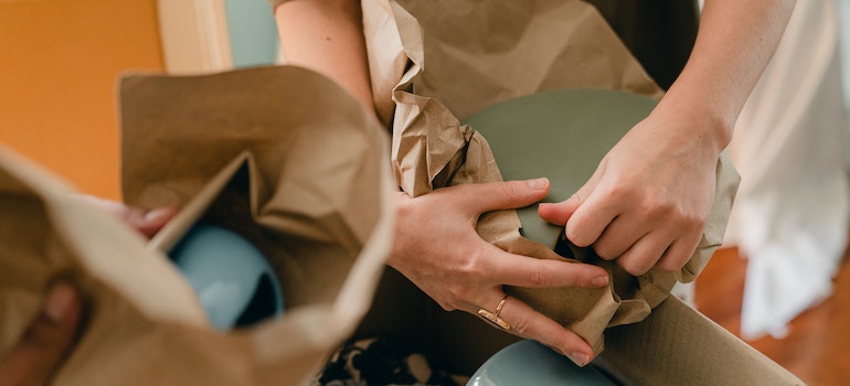 two people packing ceramic plates